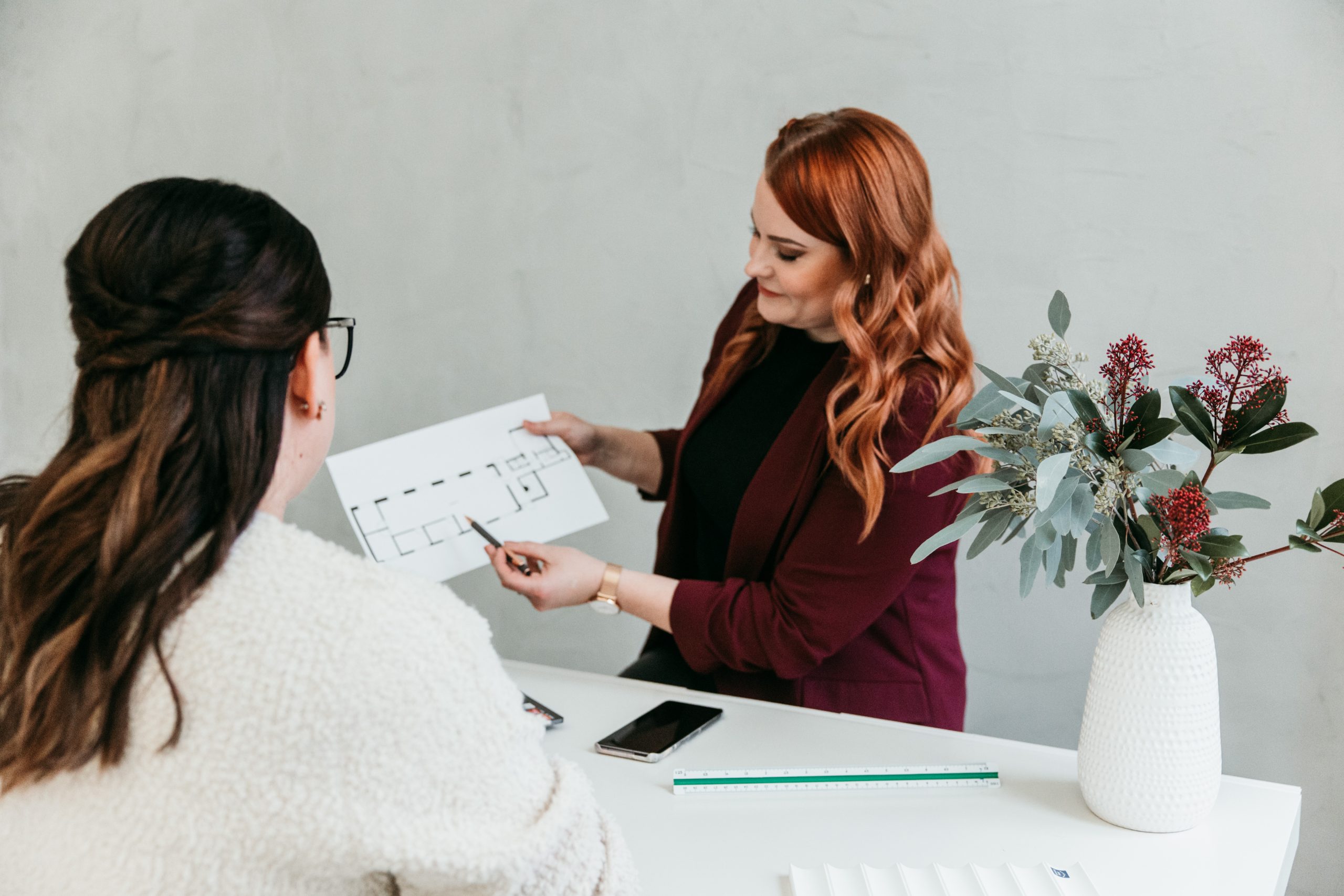 Sisustussuunnittelija Meri Rapo esittelee asiakkaalle pohjapiirrosta ja keskustelee suunnitelmista.