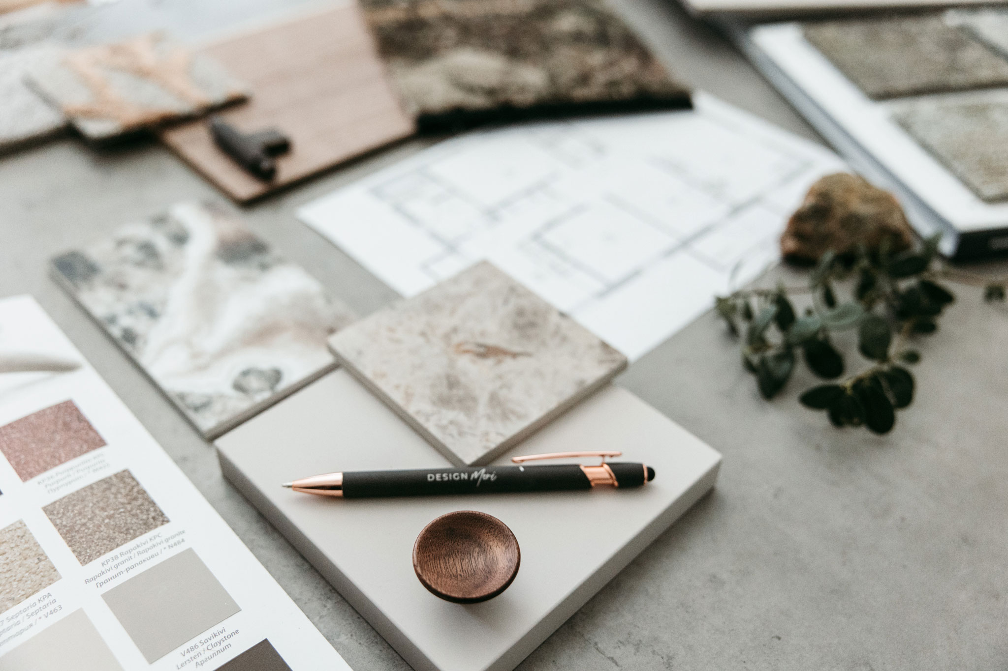 Erilaisia pintamateriaaleja ja sisustussuunnittelunäytteitä aseteltuna pöydälle.